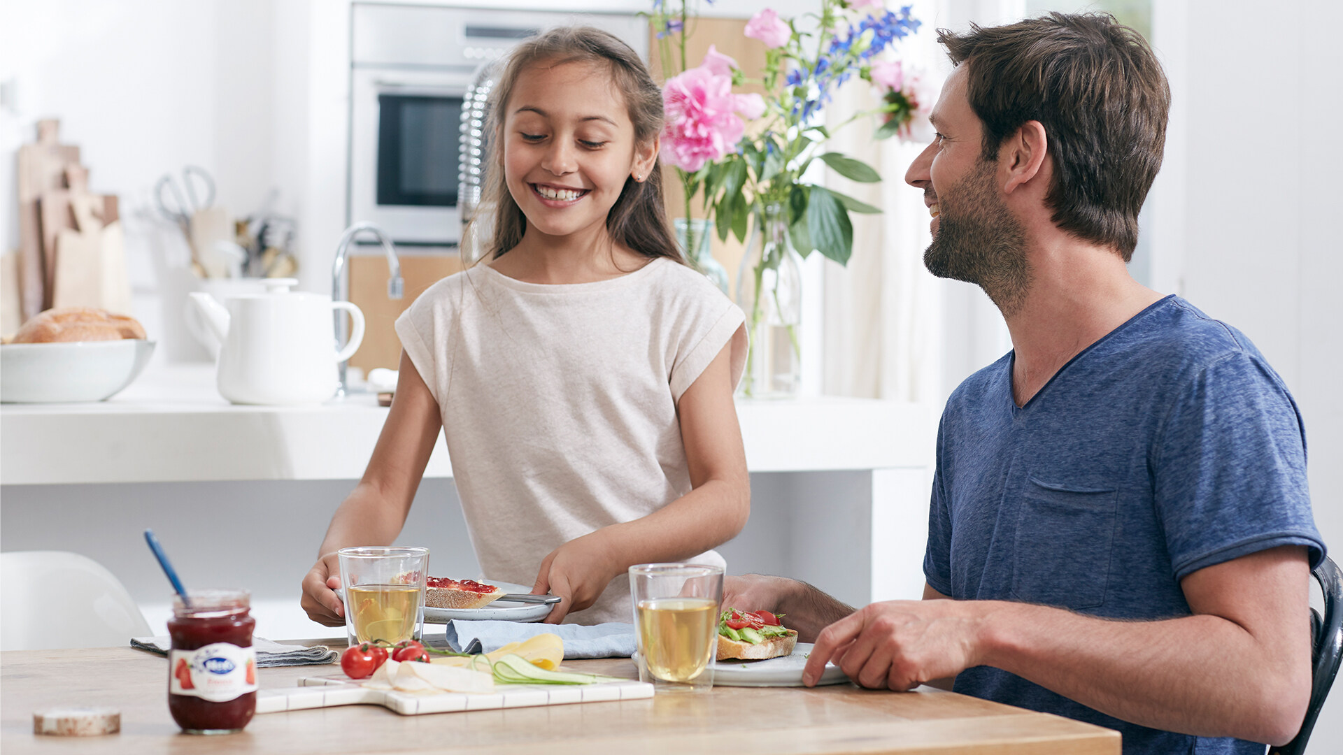 Daughter and Father smiling and enjoying Hero jams on their breakfast table